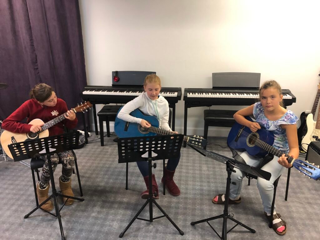 3 girls in a group guitar class